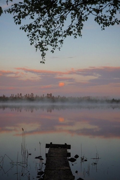 Laituri, tyyni järvenselkä ja iltarusko